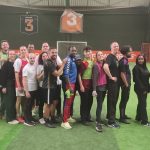 Des collègues disputent un match de foot en entreprise sur un terrain en salle, portant des dossards aux couleurs vives. Un moment de convivialité et d’esprit d’équipe illustrant la cohésion entre collaborateurs.